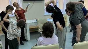Дети выполняют задание (наклоны), написанное на карточке, которую держит специалист